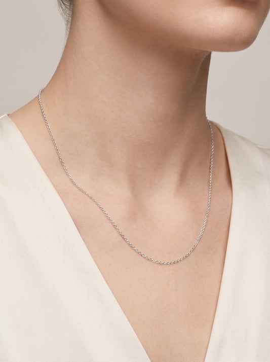 HELIOR 1.2mm platinum cable chain worn with an ivory V-neck top
