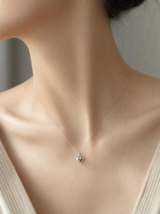 Woman wearing 10.6mm PT950 platinum heart pendant with beige knit neckline