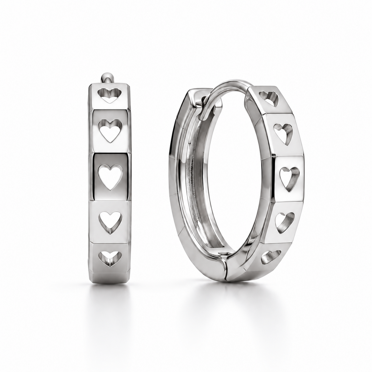 Pair of PT950 platinum huggie earrings with heart-shaped cut-outs and polished facets on a white background.