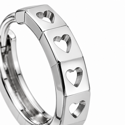 Close-up of heart-shaped openings across the flat, polished facets of a PT950 platinum hoop earring.