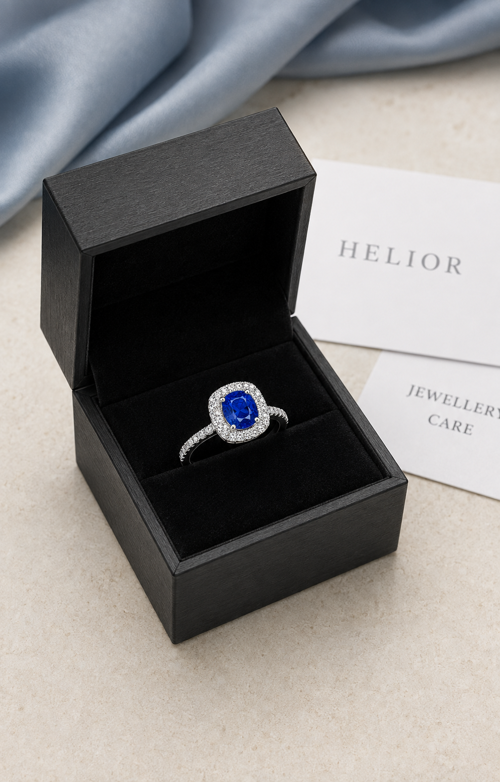 PT950 sapphire halo ring presented in a black HELIOR jewellery box