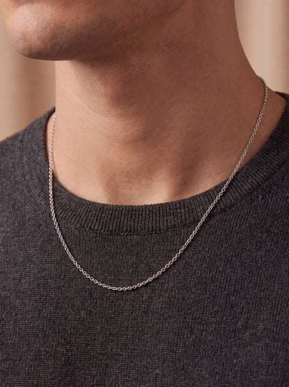 HELIOR 1.9mm platinum cable chain worn over a dark crew-neck top