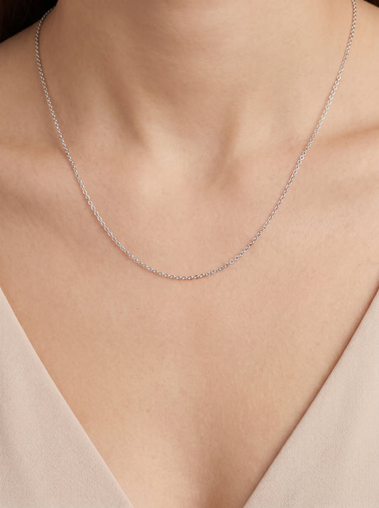 HELIOR 1.6mm platinum cable chain worn with an ivory V-neck top
