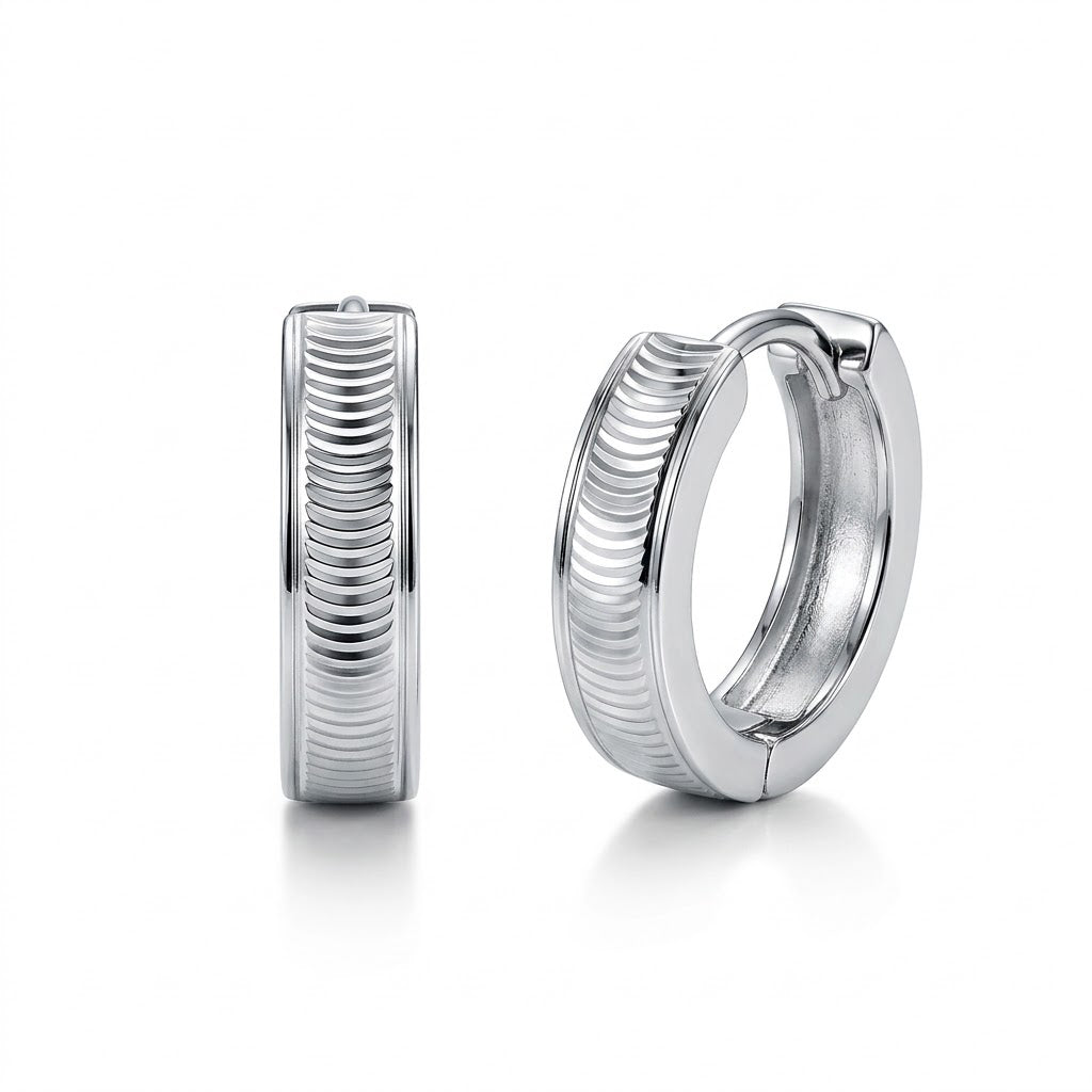Pair of Vela PT950 platinum textured huggie hoop earrings on a white background
