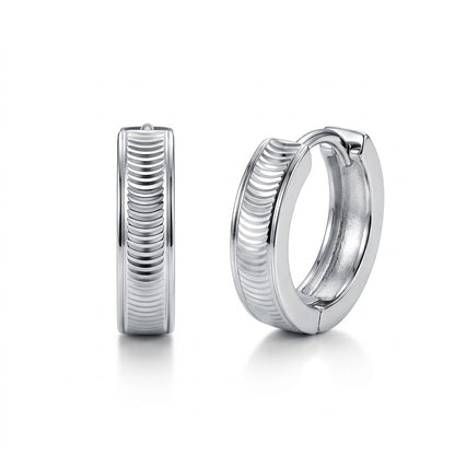 Pair of Vela PT950 platinum textured huggie hoop earrings on a white background