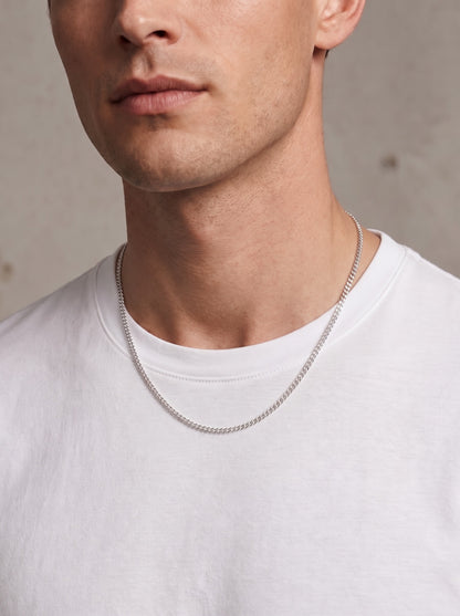 Cadence 50cm platinum curb chain necklace worn with a white shirt