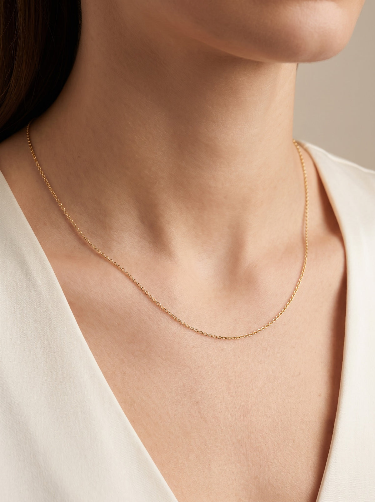 HELIOR 1.1mm 18K yellow gold cable chain necklace, worn at the neckline.