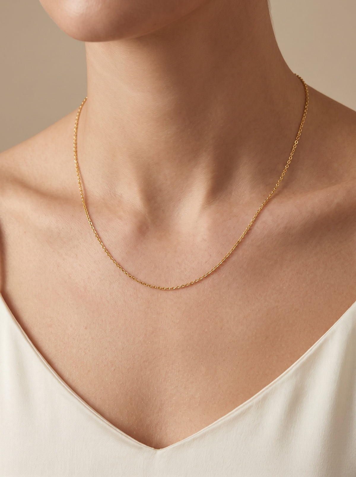 HELIOR 1.5mm 18K yellow gold cable chain necklace, worn at the neckline.