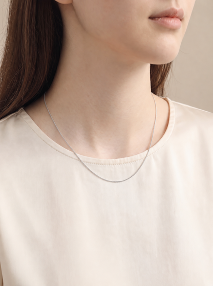 HELIOR Cadence Fine 1.2mm PT950 platinum curb chain necklace worn at 45cm with a cream blouse.