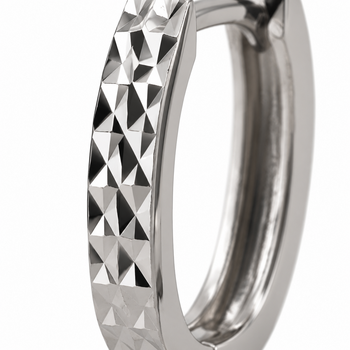 Close-up of geometric facets and polished edges on HELIOR platinum hoop earrings