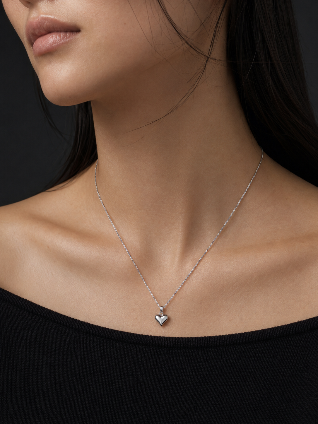 HELIOR platinum puffed heart pendant styled on a fine chain with a black neckline; pendant sold separately.
