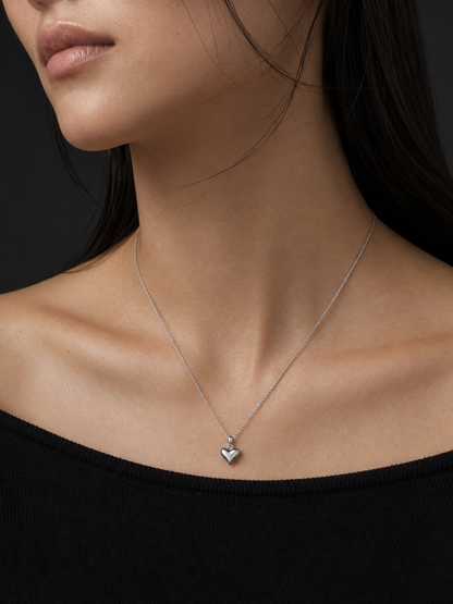 HELIOR platinum puffed heart pendant styled on a fine chain with a black neckline; pendant sold separately.