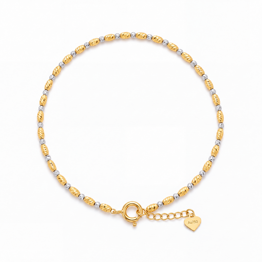 HELIOR Tempo 18K gold two-tone bracelet with alternating faceted beads, a spring-ring clasp and heart-shaped extender tag.