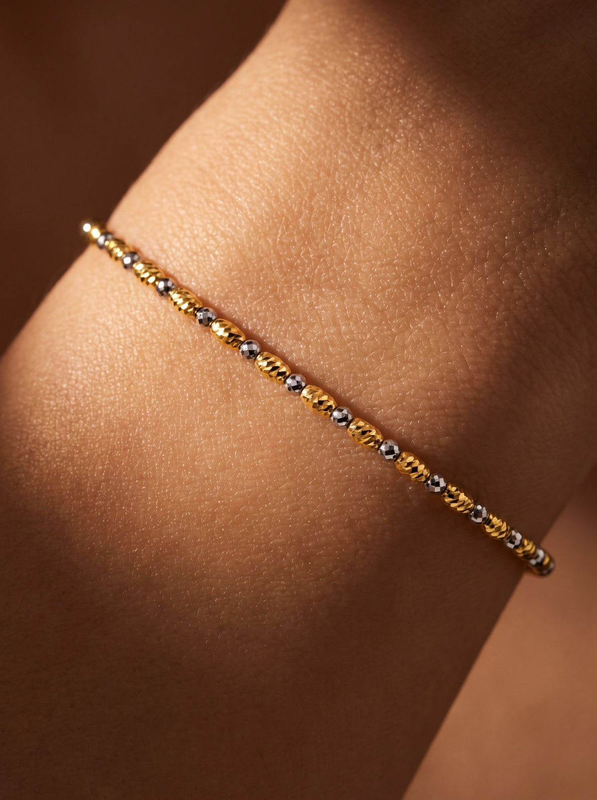 Close wrist view of the HELIOR Tempo bracelet and its alternating yellow and white-coloured faceted beads.
