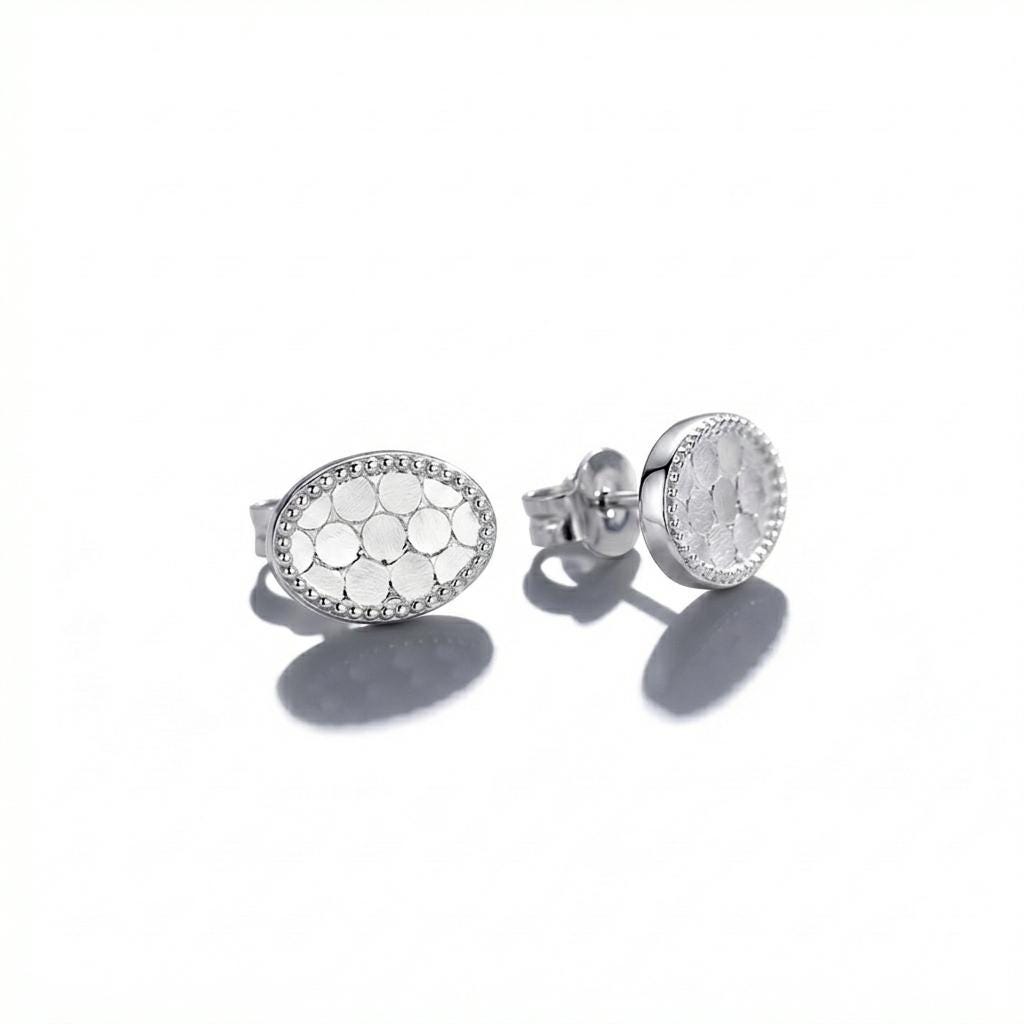 Angled pair of PT950 textured oval milgrain stud earrings