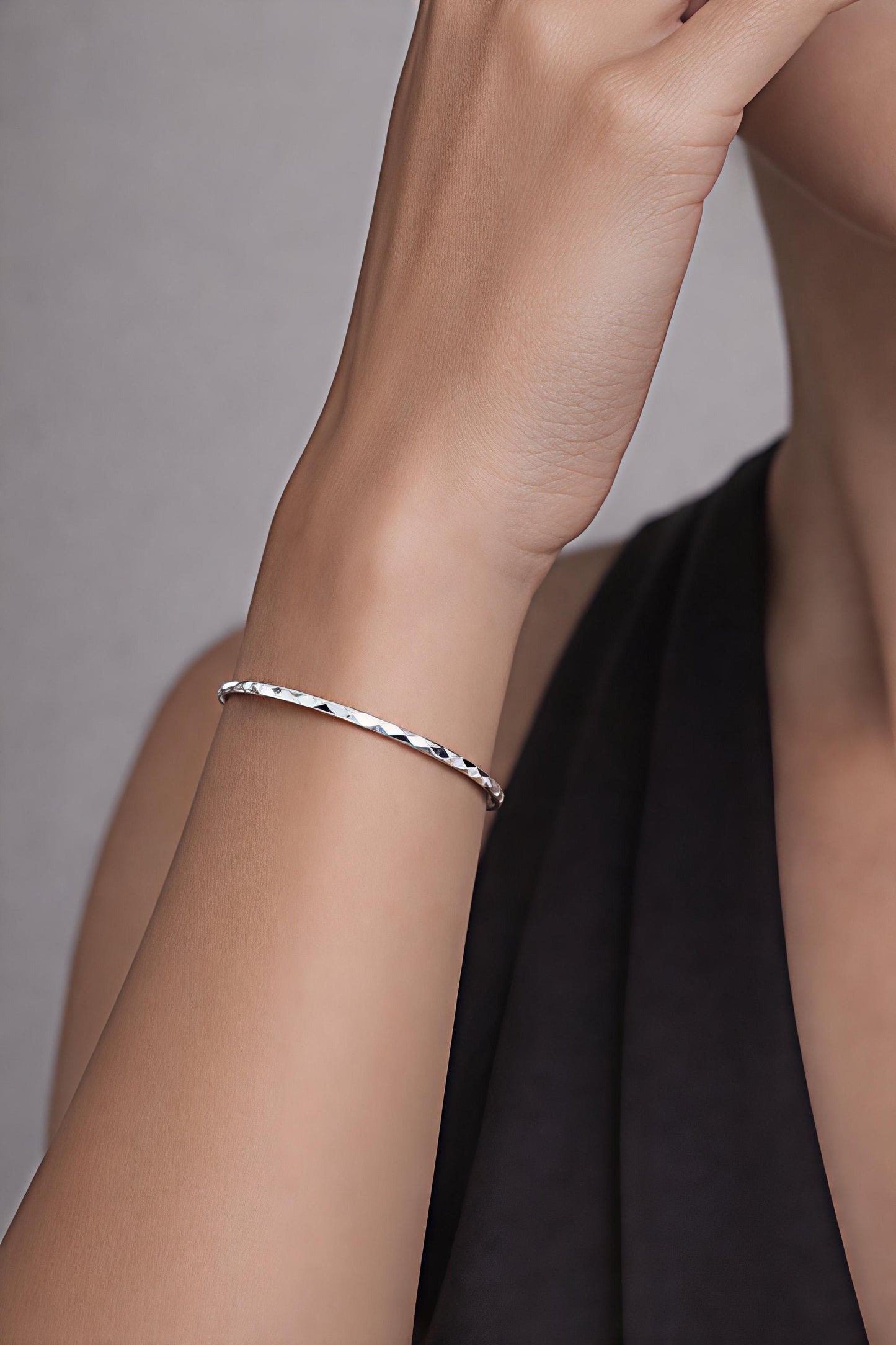 Woman wearing 3mm geometric faceted platinum bangle