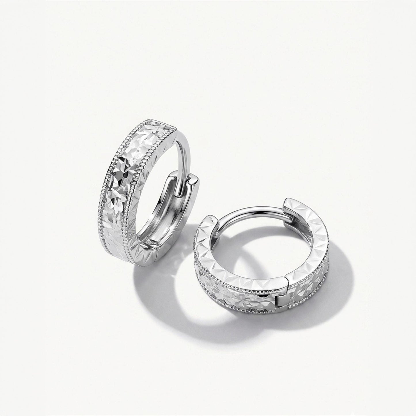 Solid PT950 diamond-cut milgrain huggie hoop earrings on white