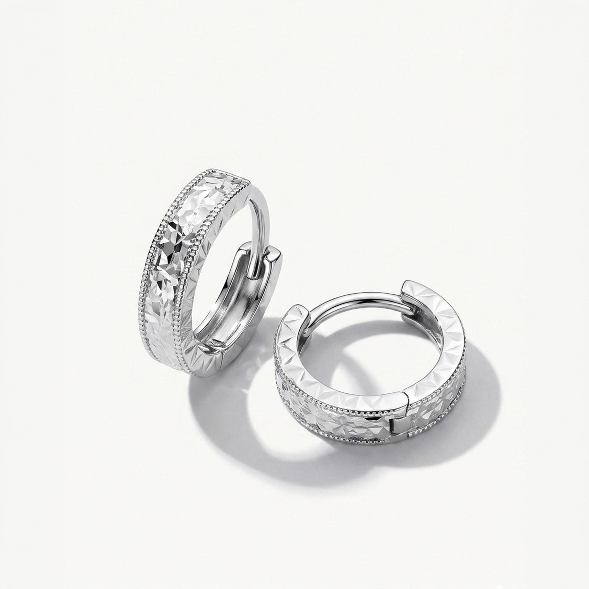 Solid PT950 diamond-cut milgrain huggie hoop earrings on white