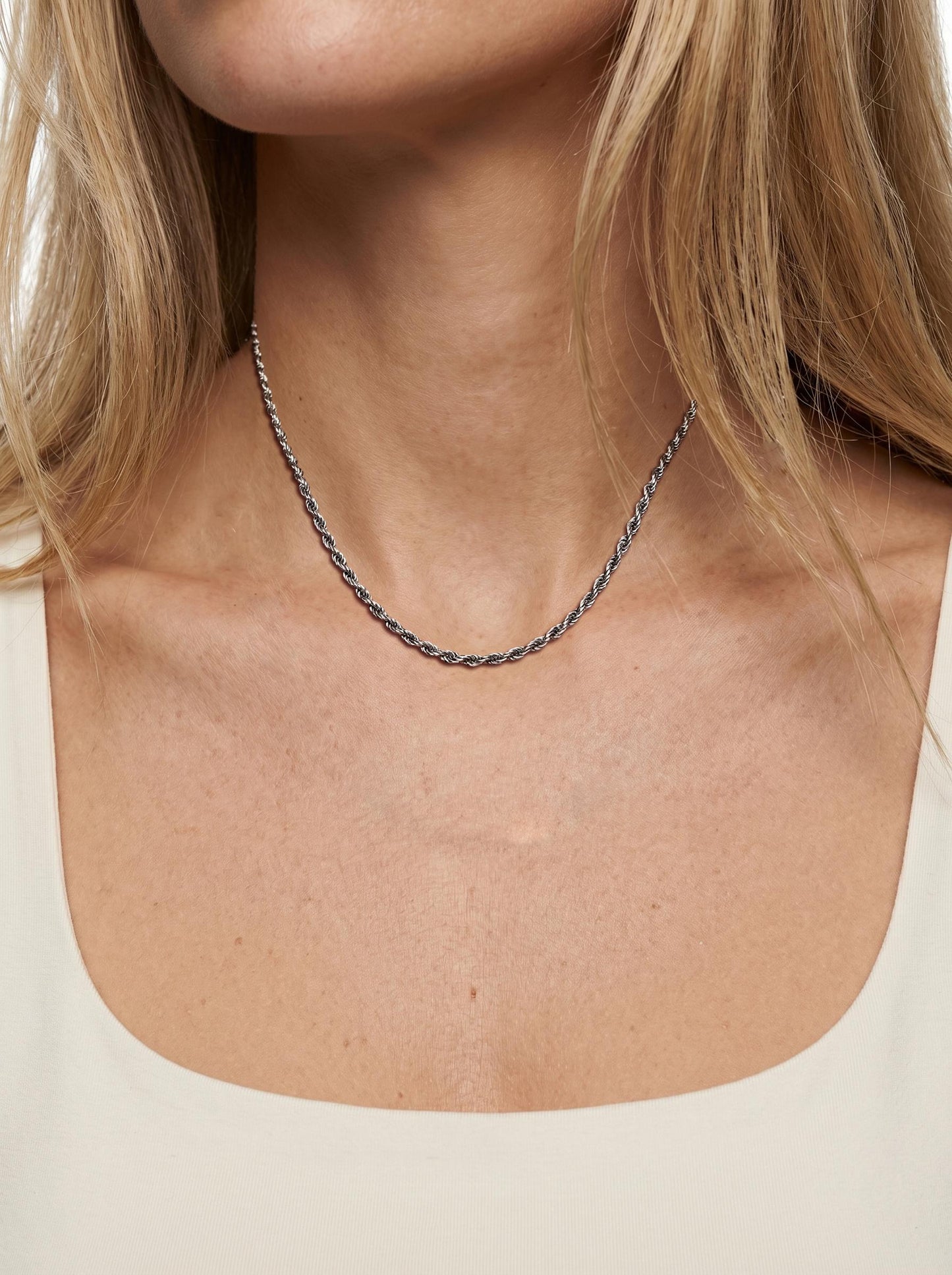 Woman wearing heavyweight 2.2mm platinum rope chain with cream neckline