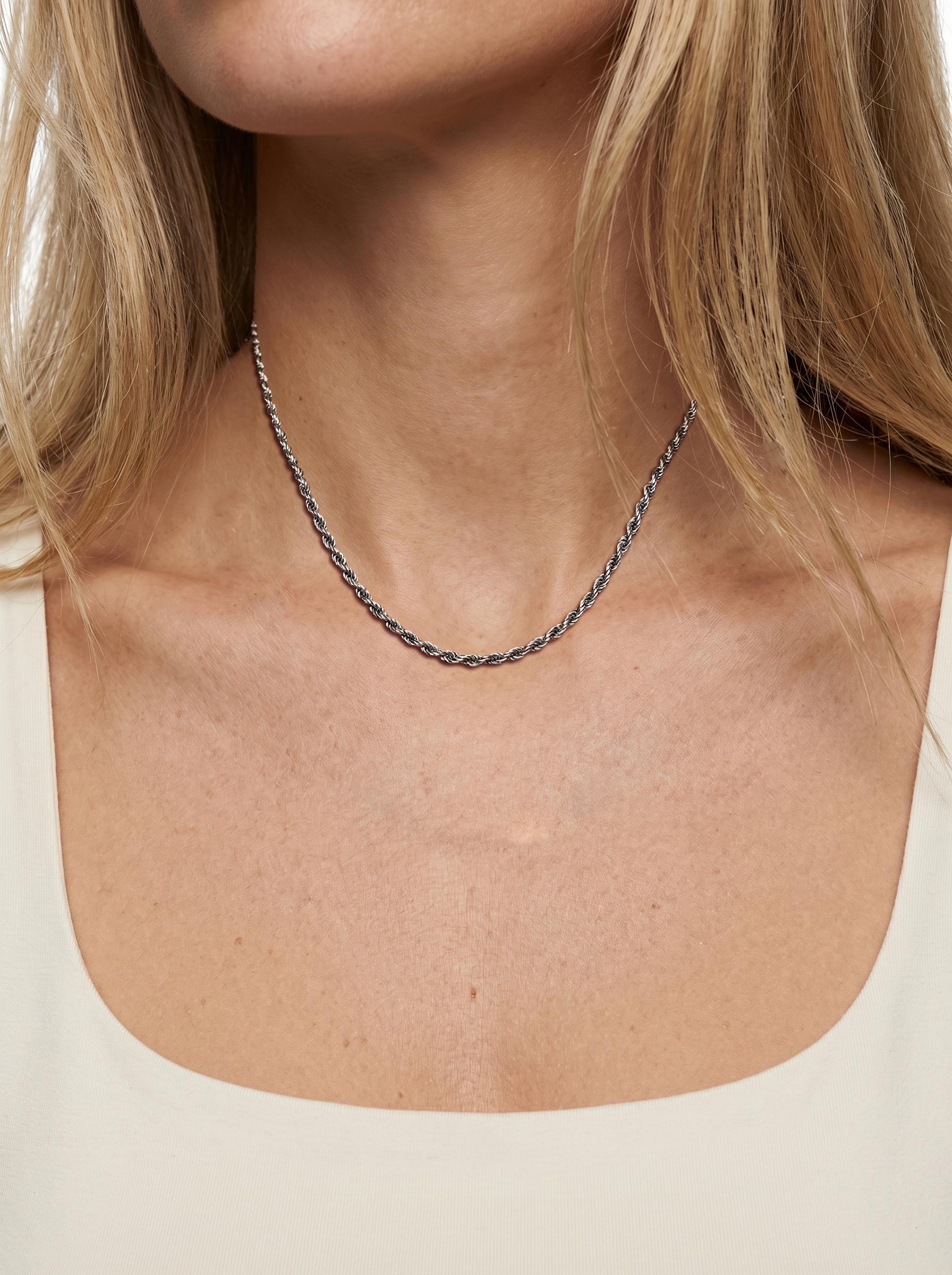 Woman wearing heavyweight 2.2mm platinum rope chain with cream neckline
