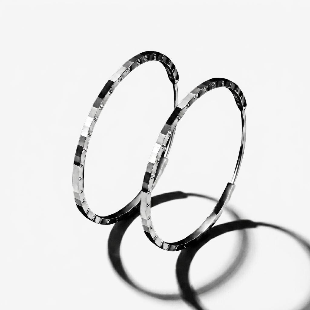 Angled pair of PT950 diamond-cut platinum hoop earrings
