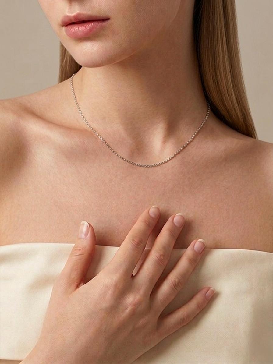 Woman wearing 1mm platinum cable necklace with cream off-shoulder top