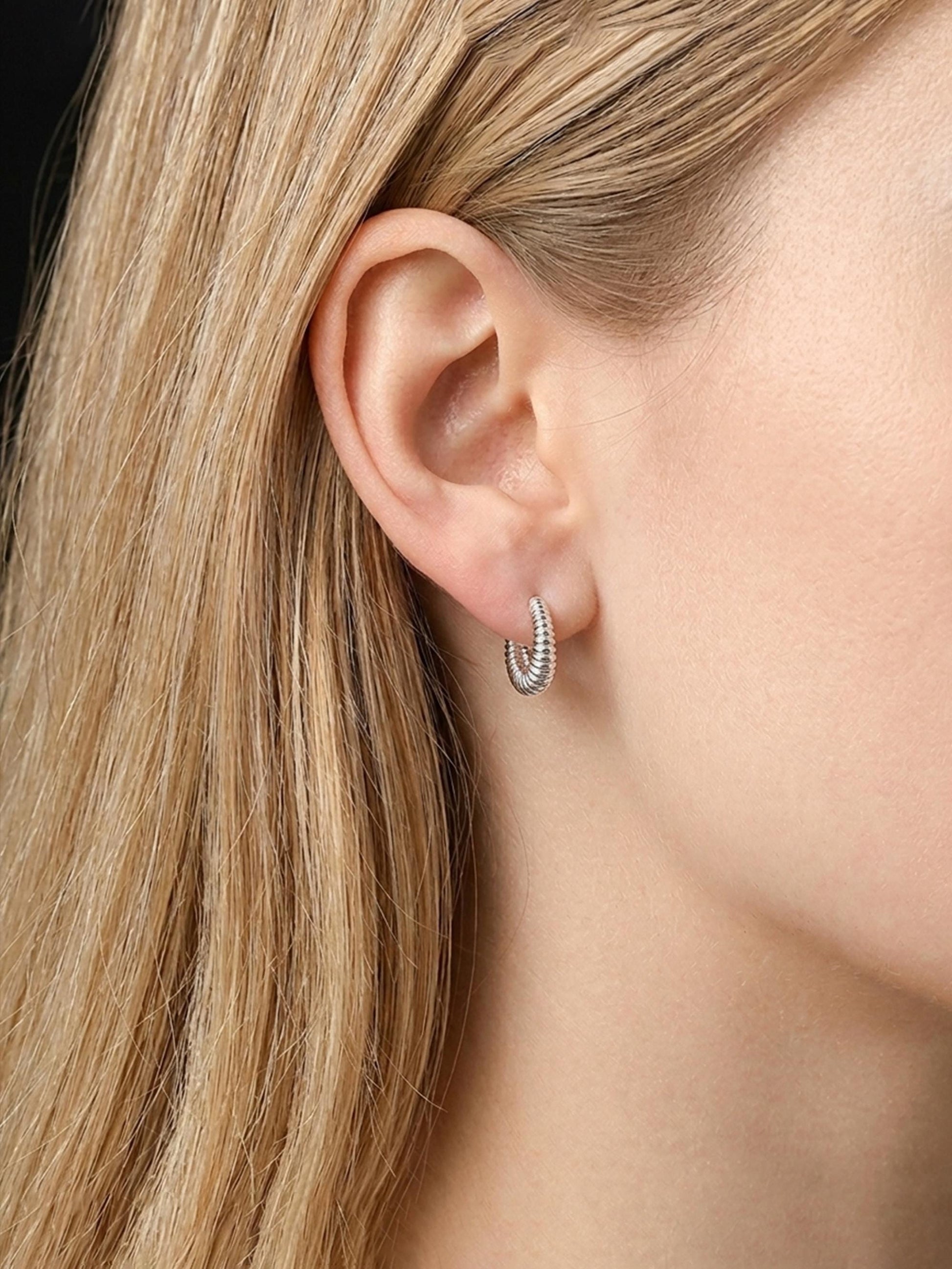 Model wearing solid PT950 ribbed 12mm huggie earrings