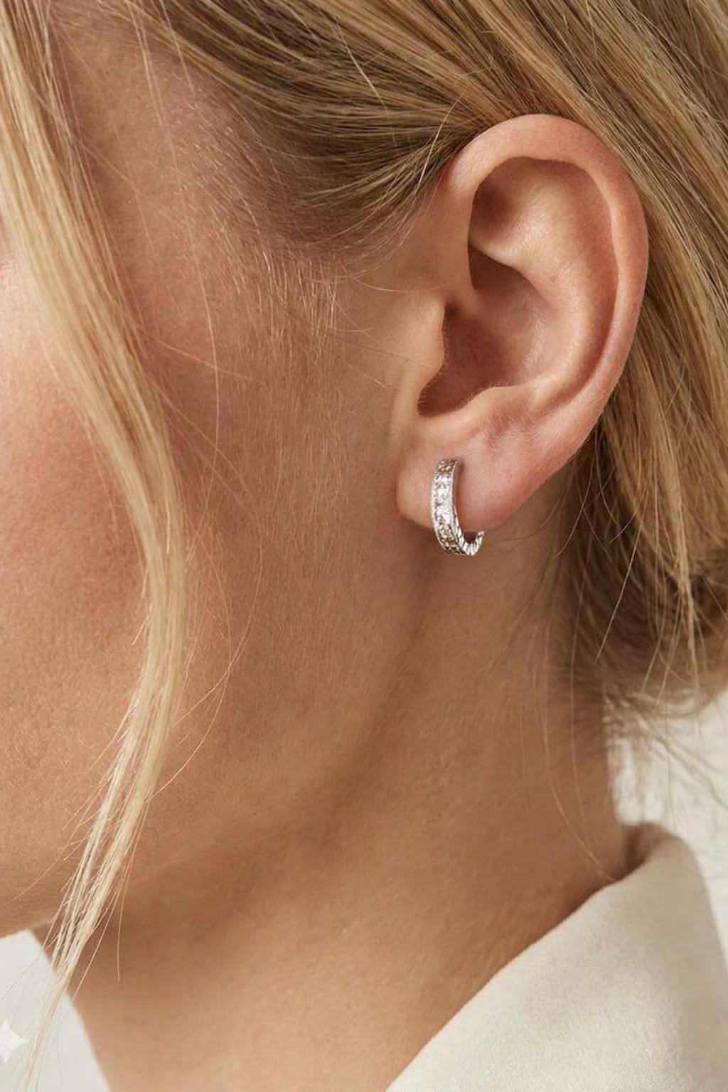 Model wearing solid PT950 diamond-cut huggie earrings