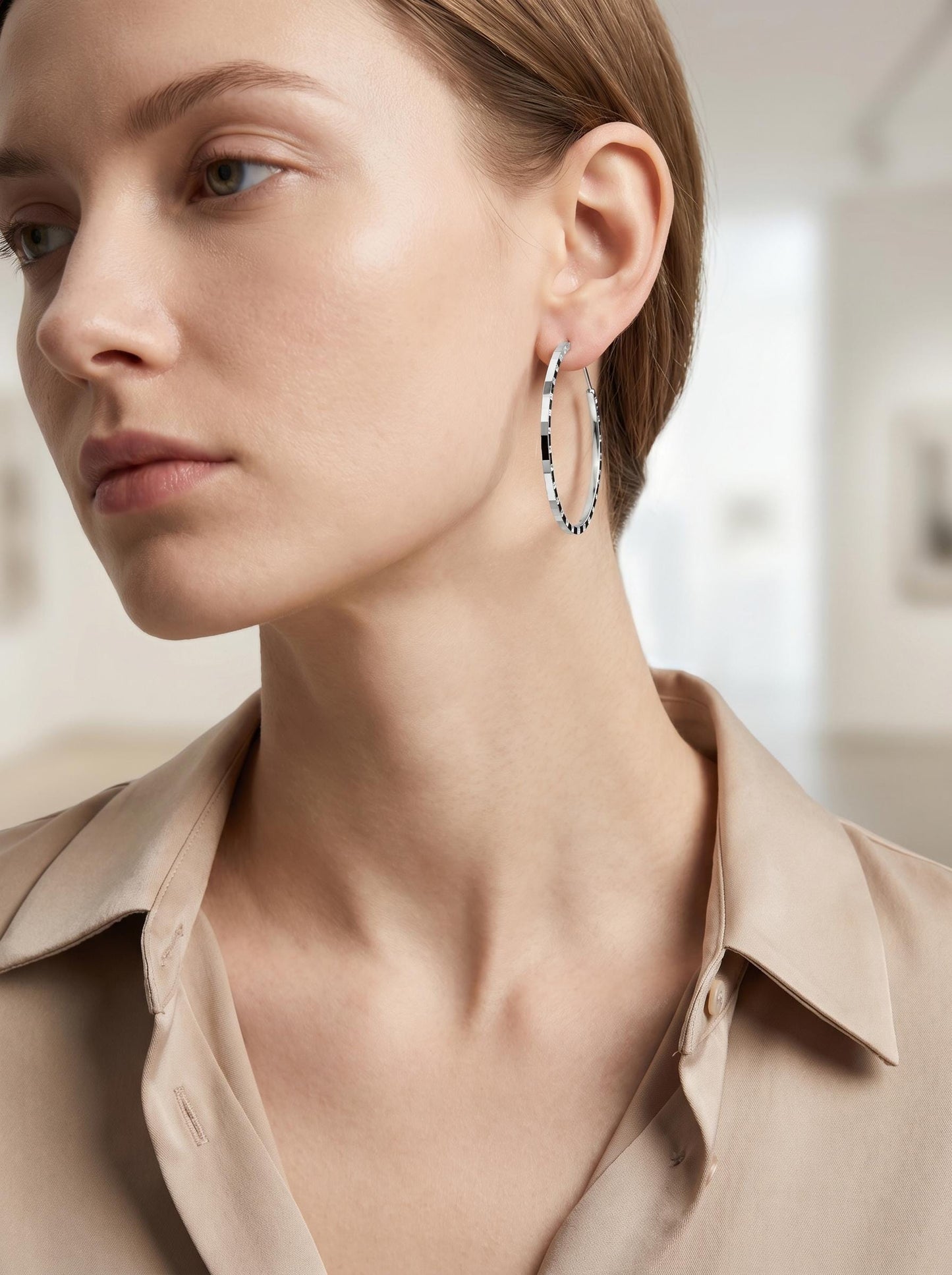 Model wearing medium solid PT950 diamond-cut hoop earrings
