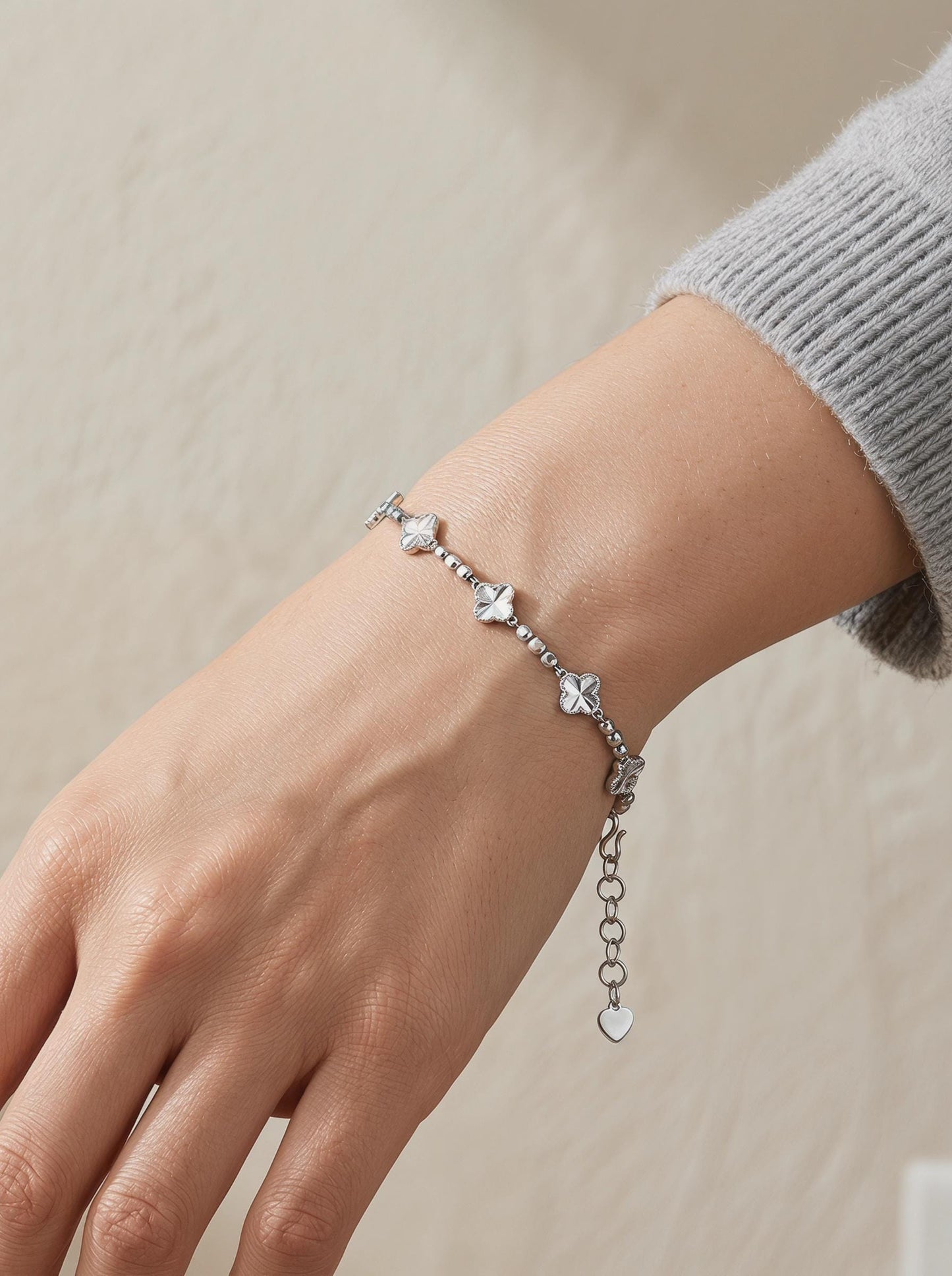 Woman wearing platinum clover and faceted bead bracelet