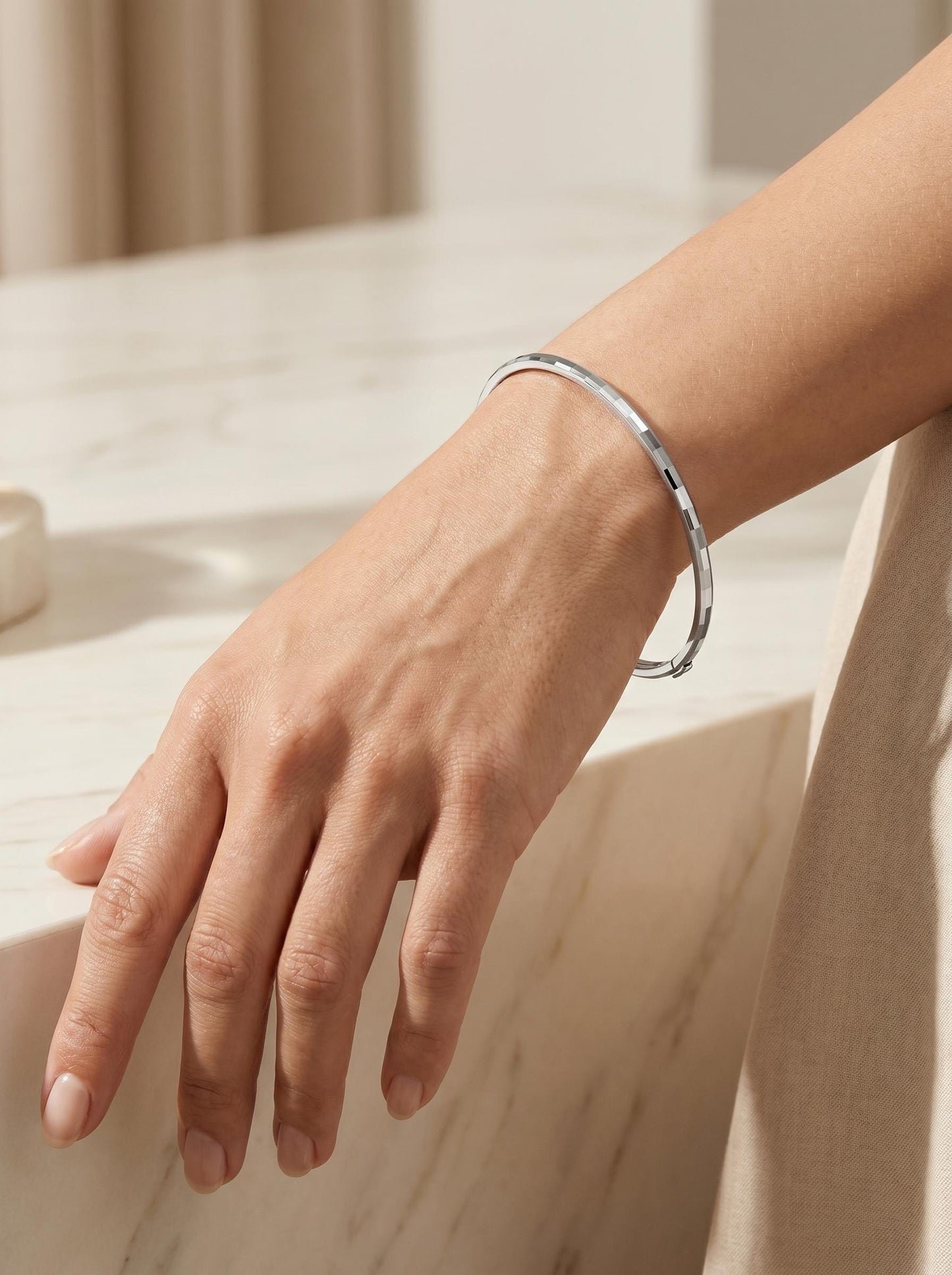 Close wrist view of textured hinged platinum bangle