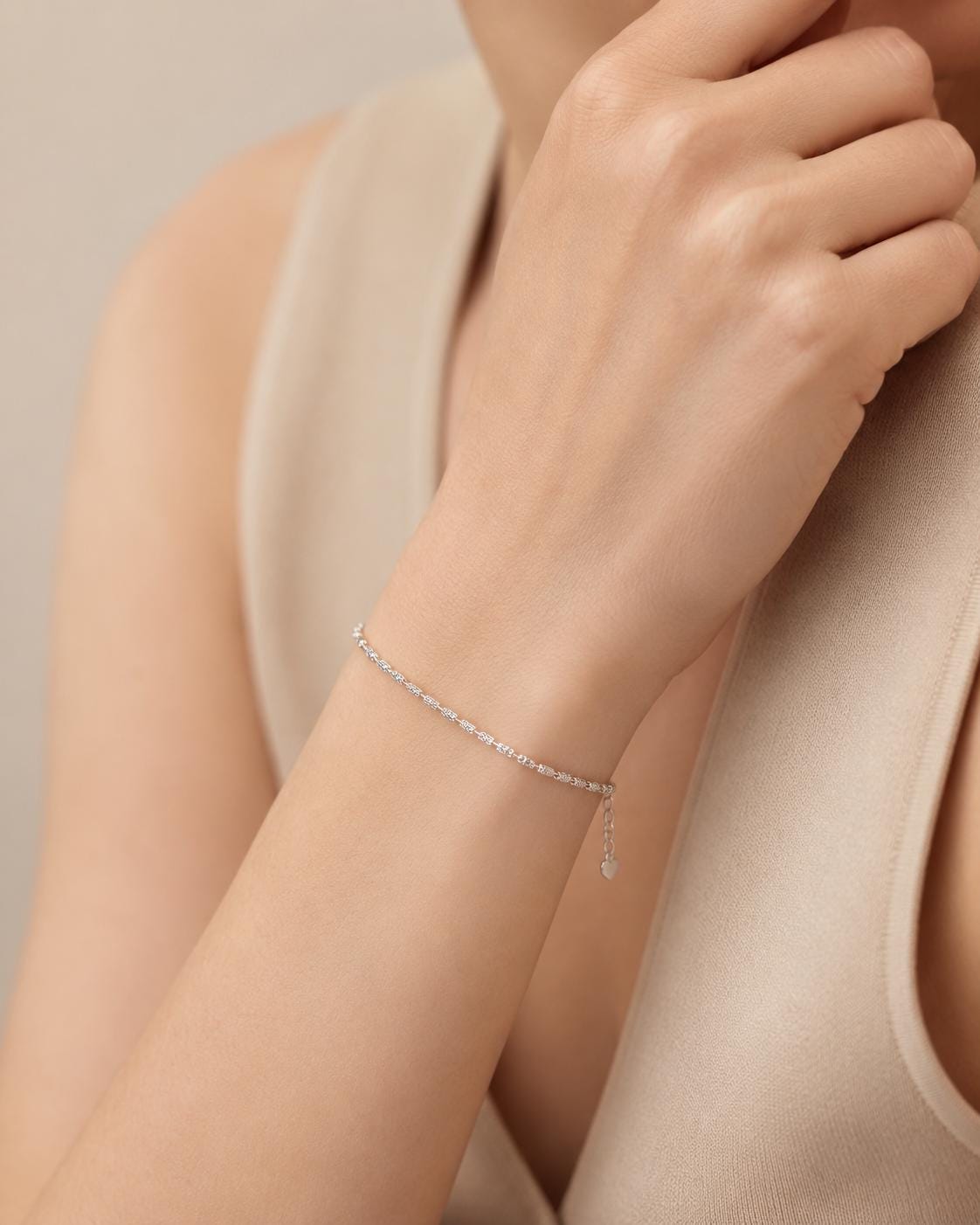 Woman wearing slim platinum ripple-link bracelet
