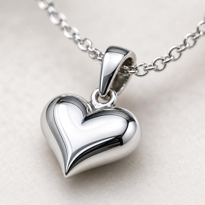 Macro detail of polished platinum heart pendant and integrated bail