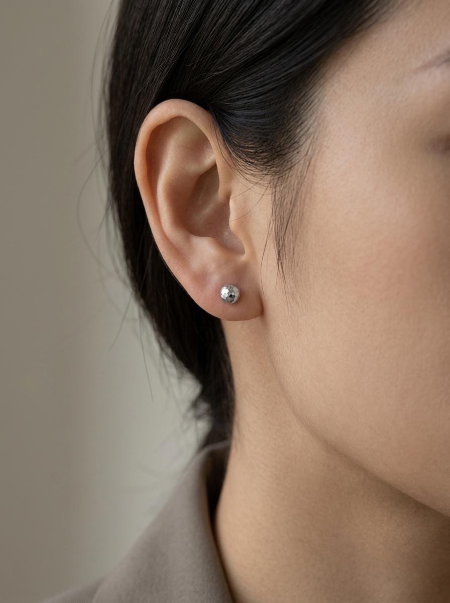 Model wearing solid PT950 faceted ball stud earrings