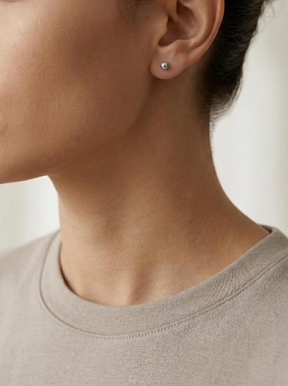 Model wearing PT950 faceted ball stud earrings in profile
