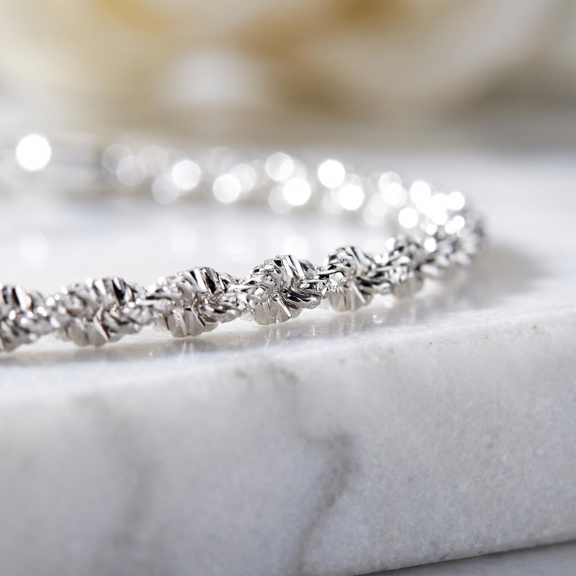 Faceted platinum chain texture in soft light