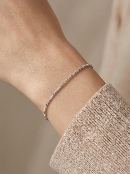 Woman wearing 1.5mm faceted platinum chain bracelet