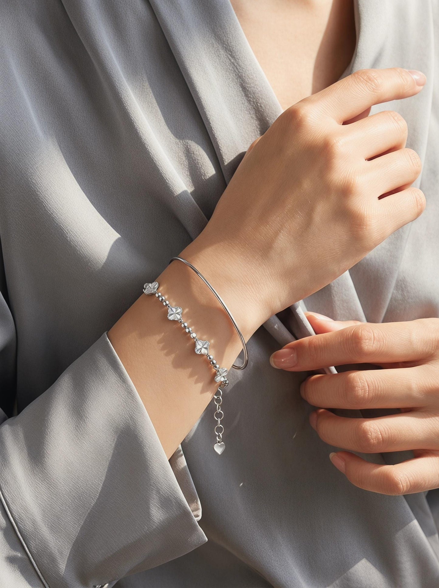 Platinum clover bracelet layered with polished bangle