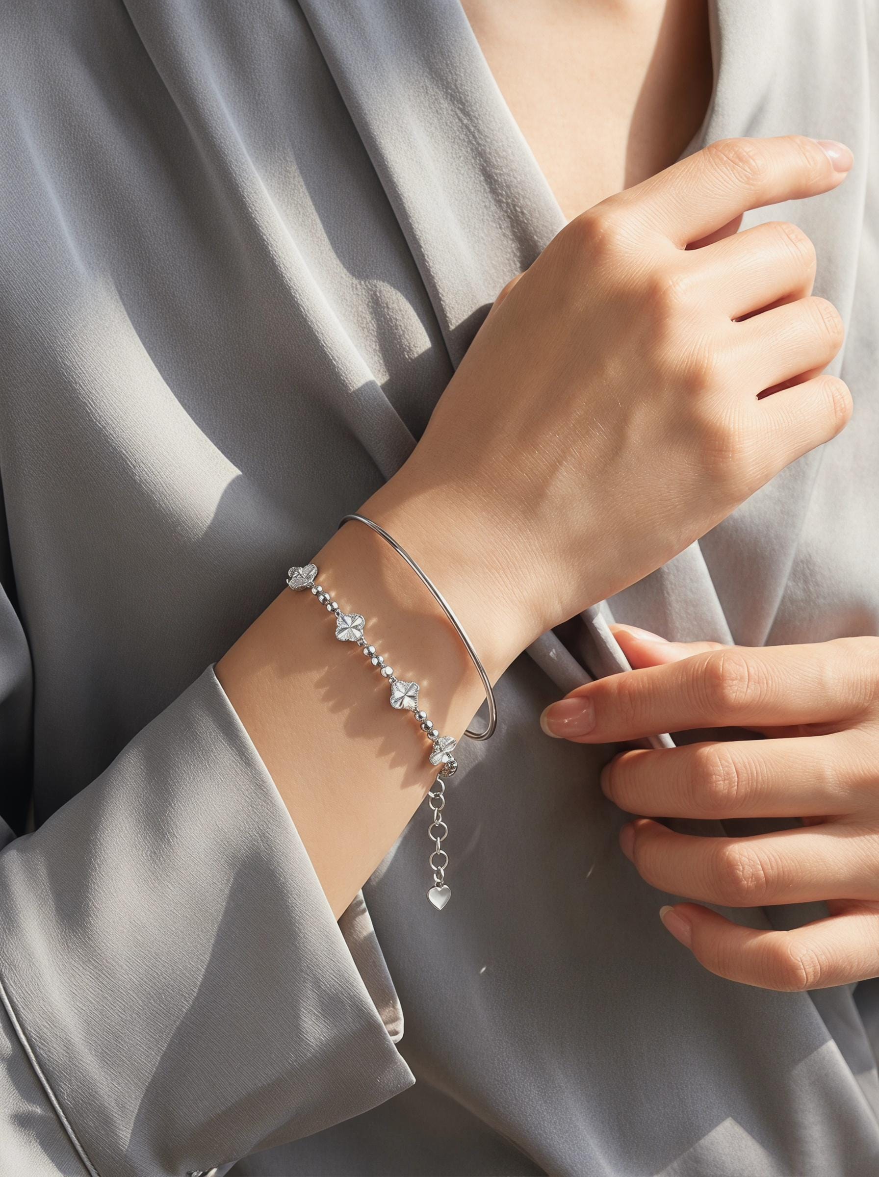 Platinum clover bracelet layered with polished bangle