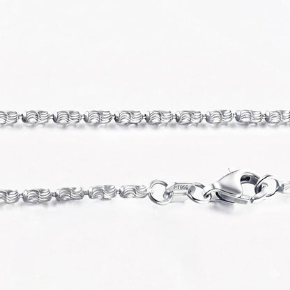 Macro detail of laser-cut platinum olive beads, lobster clasp and PT950 tag
