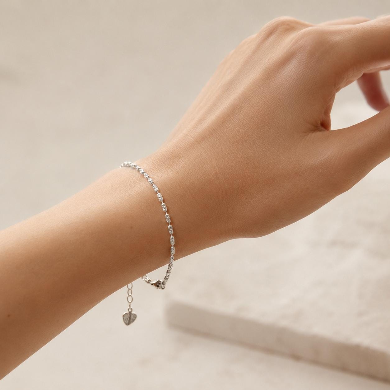 Adjustable platinum ripple-link bracelet worn on wrist