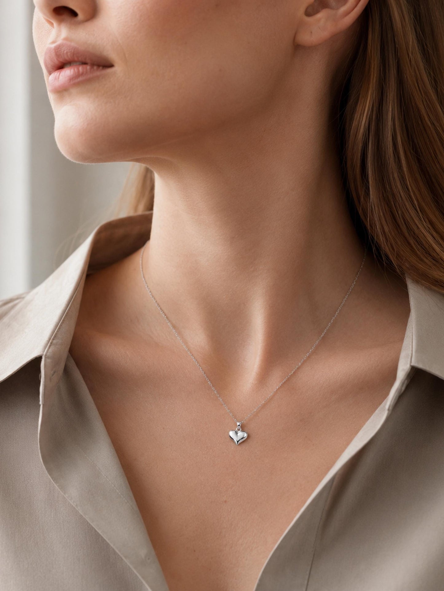 Close neckline view of PT950 platinum heart pendant with beige blouse