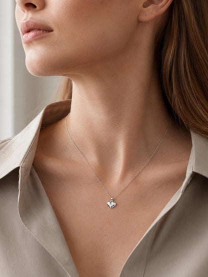 Close neckline view of PT950 platinum heart pendant with beige blouse