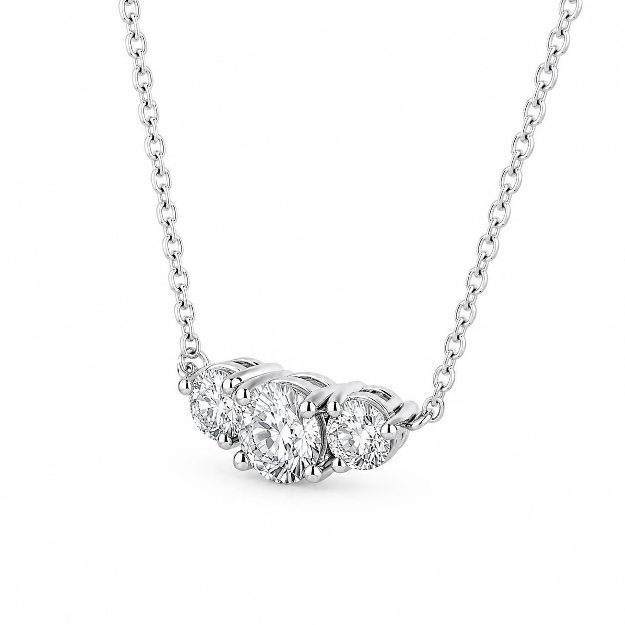 Angled detail of platinum prong settings on three-stone diamond pendant