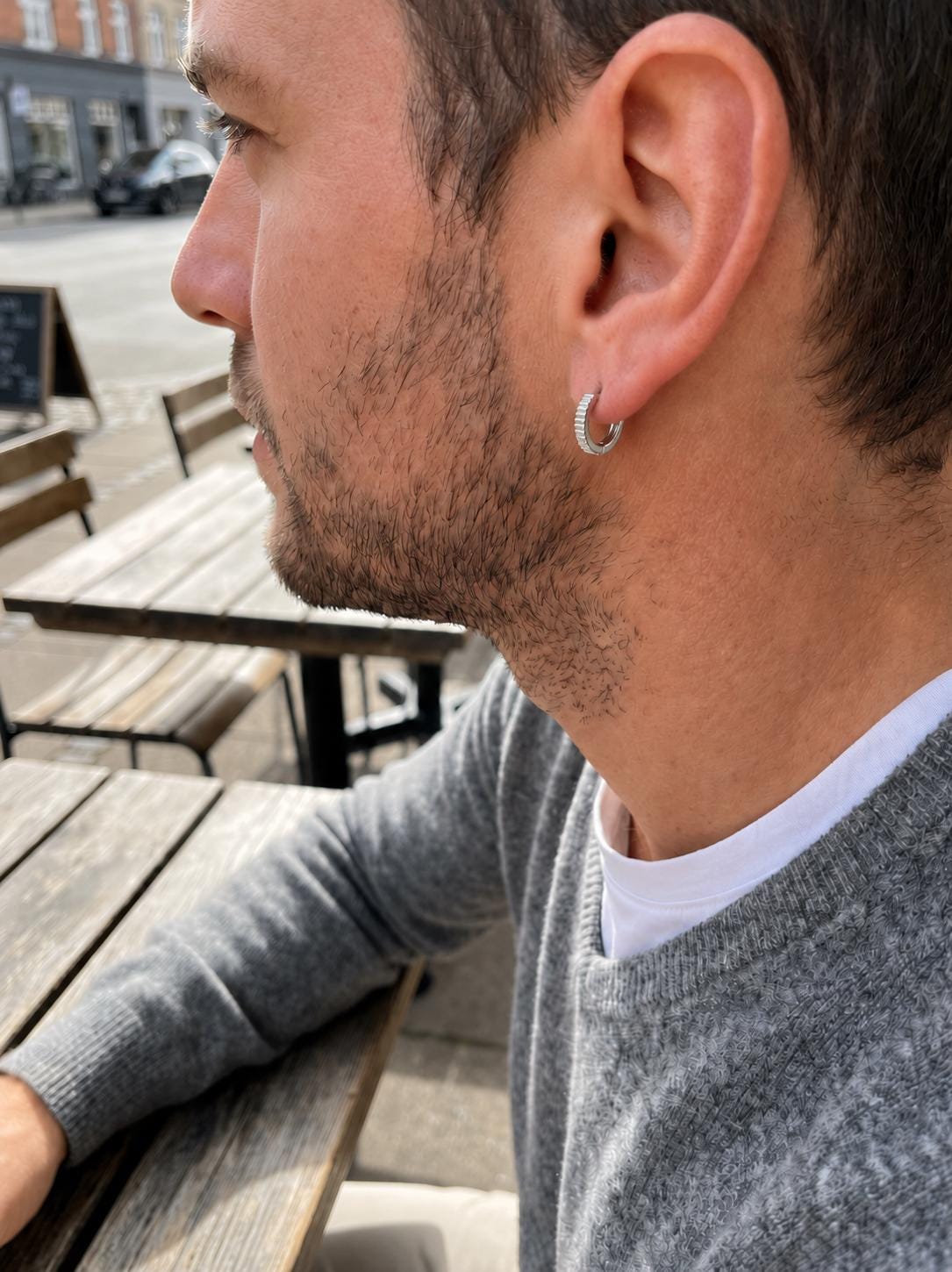 Man wearing solid PT950 ridged huggie hoop earrings
