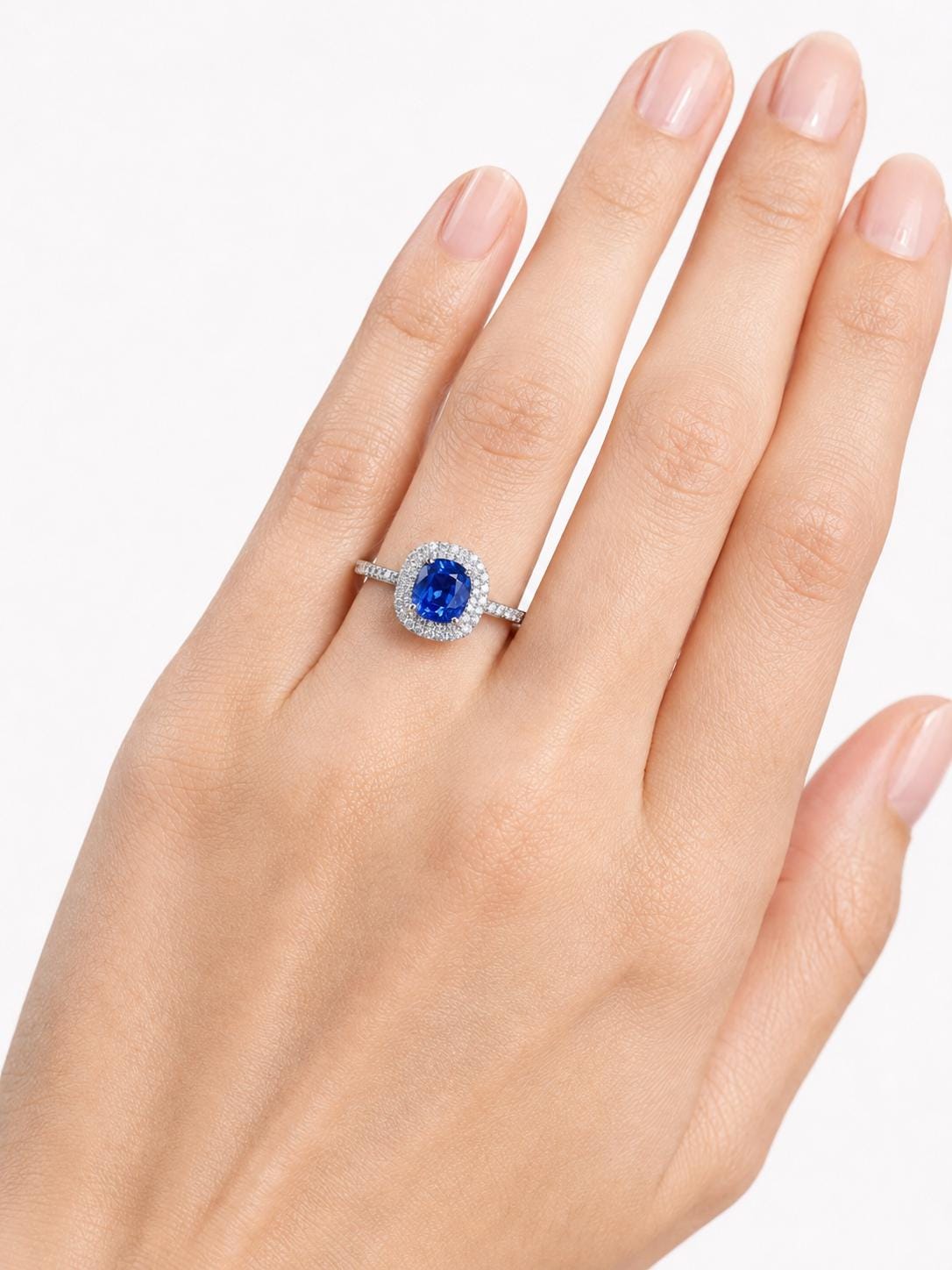 deep blue sapphire and diamond halo ring in PT950 platinum worn view