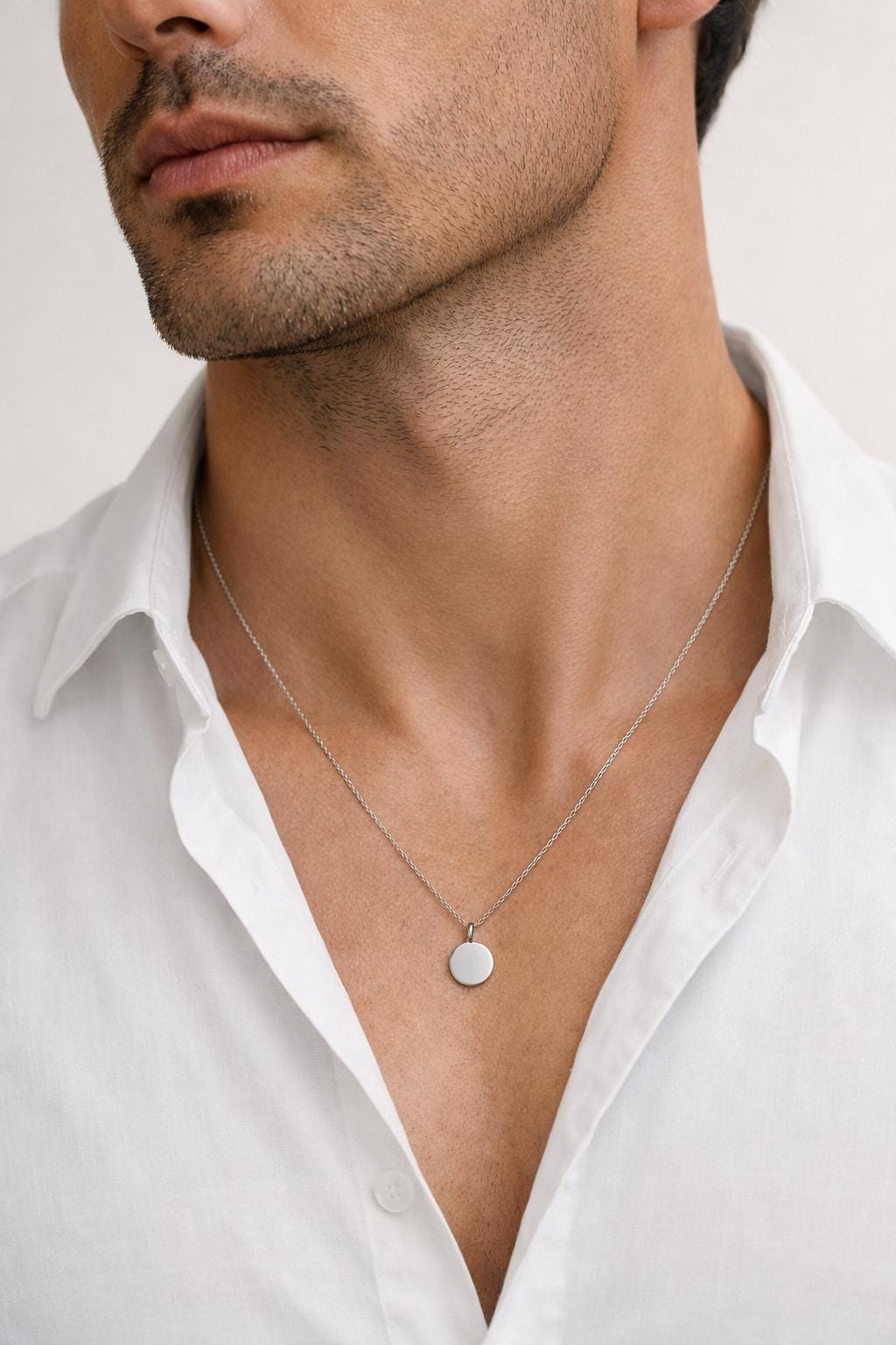 Man wearing personalised platinum disc necklace with white shirt