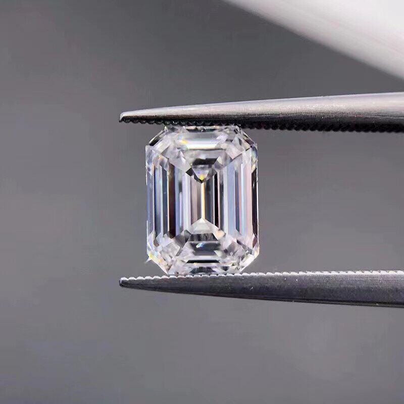 Loose emerald-cut lab-grown diamond held in tweezers