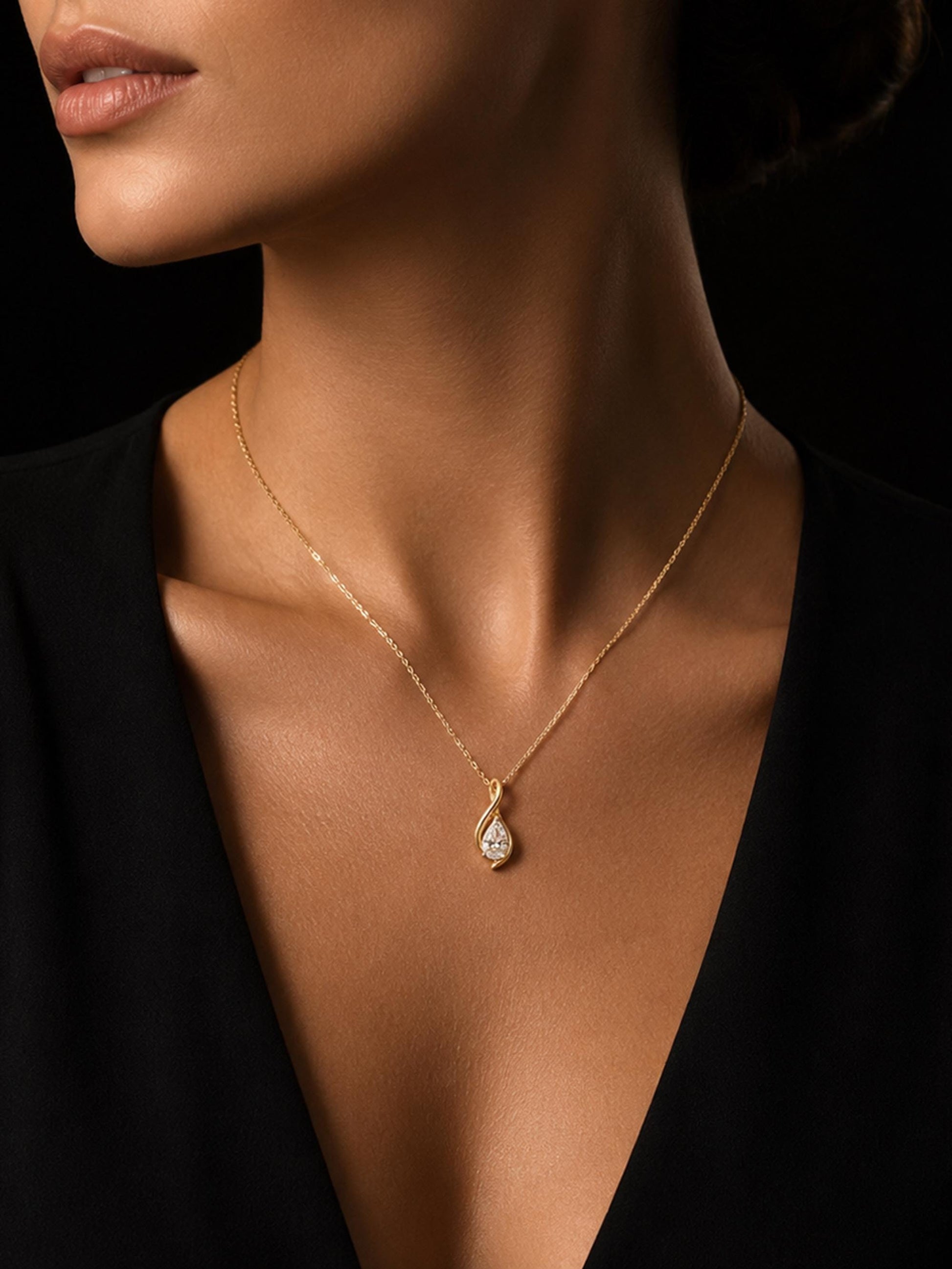 Woman wearing pear lab diamond twist necklace with black V-neck