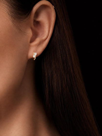 Model wearing 18K gold pear cluster lab diamond huggie earrings